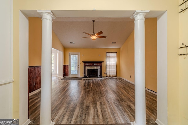 123 Chippewa Run, Auburn, GA 30011 - unfurnished living room featuring lofted ceiling, wood finished floors, ceiling fan, a fireplace with raised hearth, and ornate columns