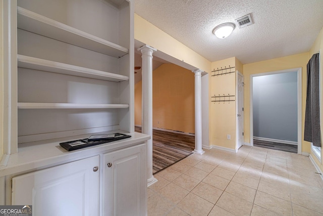 123 Chippewa Run, Auburn, GA 30011 - hall featuring a textured ceiling, decorative columns, baseboards, and light tile patterned floors