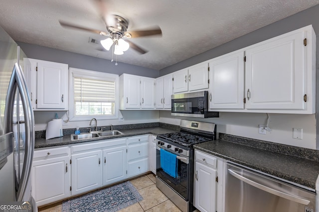 102 Fern Way, Thomaston, GA 30286 - kitchen featuring stainless steel appliances, a sink, a ceiling fan, dark countertops, and white cabinets