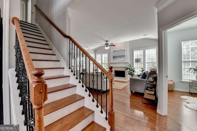475 Bayswater Way, Suwanee, GA 30024 - staircase with a ceiling fan, wood finished floors, healthy amount of natural light, a fireplace with raised hearth, and vaulted ceiling