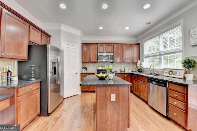 475 Bayswater Way, Suwanee, GA 30024 - kitchen with stainless steel appliances, a center island, light wood-style floors, dark stone counters, and ornamental molding