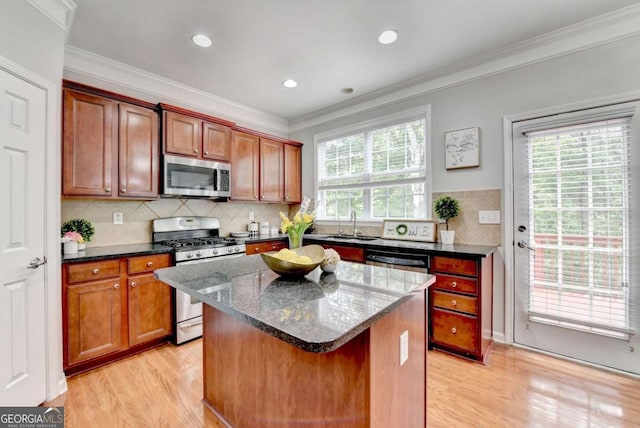 475 Bayswater Way, Suwanee, GA 30024 - kitchen featuring stainless steel appliances, light wood finished floors, ornamental molding, dark stone countertops, and a kitchen island