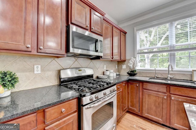 475 Bayswater Way, Suwanee, GA 30024 - kitchen with stainless steel appliances, ornamental molding, dark stone countertops, light wood-style flooring, and tasteful backsplash
