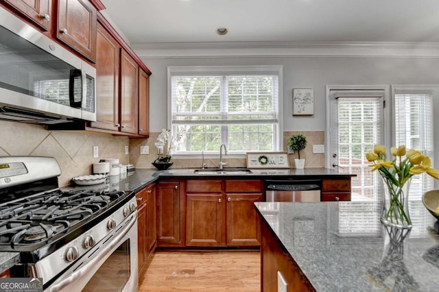 475 Bayswater Way, Suwanee, GA 30024 - kitchen with appliances with stainless steel finishes, dark stone countertops, ornamental molding, light wood finished floors, and backsplash