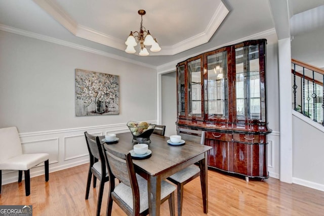 475 Bayswater Way, Suwanee, GA 30024 - dining space featuring a chandelier, light wood-style flooring, ornamental molding, a decorative wall, and a tray ceiling
