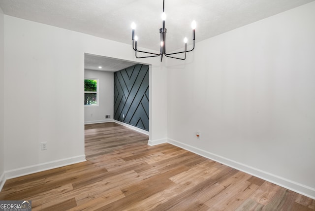 7455 Dover Ct, Riverdale, GA 30274 - unfurnished dining area featuring a chandelier, light wood-style flooring, and baseboards