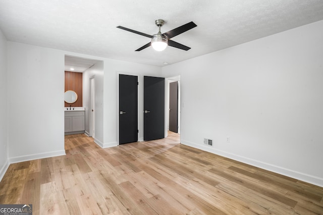 7455 Dover Ct, Riverdale, GA 30274 - unfurnished bedroom featuring light wood-style floors, baseboards, ensuite bath, attic access, and a ceiling fan