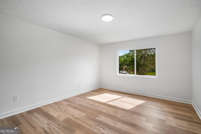 7455 Dover Ct, Riverdale, GA 30274 - empty room with light wood-type flooring, baseboards, and a textured ceiling