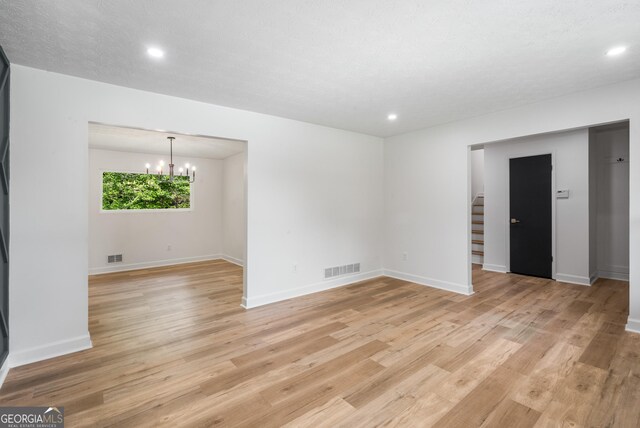 7455 Dover Ct, Riverdale, GA 30274 - spare room with a chandelier, light wood-style flooring, recessed lighting, stairway, and baseboards