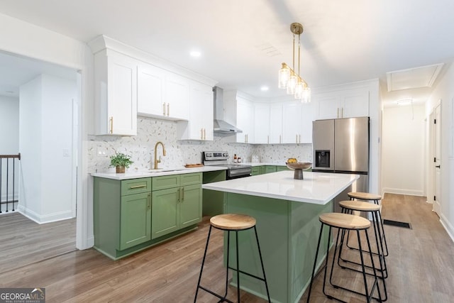 398 Baker Cir NW, Atlanta, GA 30318 - kitchen featuring green cabinetry, stainless steel appliances, wall chimney range hood, a sink, and white cabinets