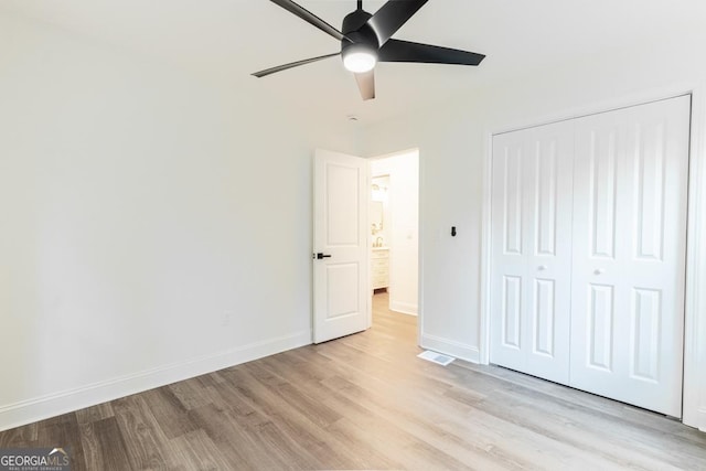 398 Baker Cir NW, Atlanta, GA 30318 - unfurnished bedroom with light wood-style floors, baseboards, a closet, and a ceiling fan