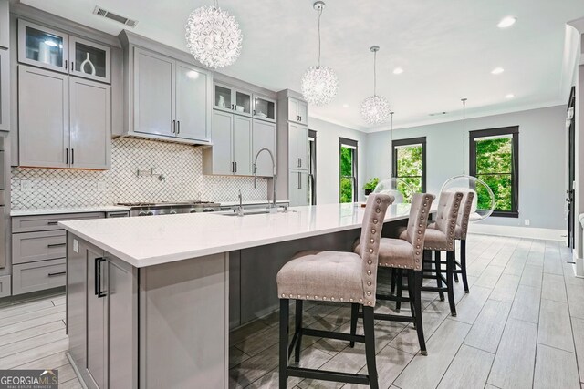 2804 Skyland Dr NE, Brookhaven, GA 30341 - kitchen featuring gray cabinets, a chandelier, a sink, decorative backsplash, and crown molding