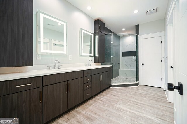 2804 Skyland Dr NE, Brookhaven, GA 30341 - bathroom with wood finished floors, double vanity, a marble finish shower, and recessed lighting