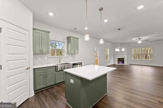 325 Magnolia Villas Dr, Cornelia, GA 30531 - kitchen with green cabinetry, a sink, light countertops, a lit fireplace, and dark wood finished floors