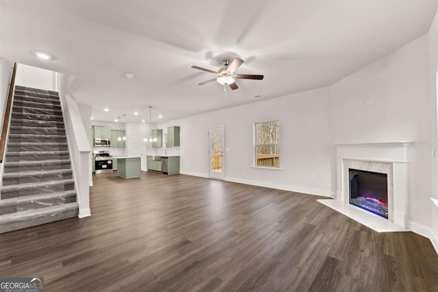 325 Magnolia Villas Dr, Cornelia, GA 30531 - unfurnished living room with a ceiling fan, stairway, dark wood-style floors, a premium fireplace, and baseboards