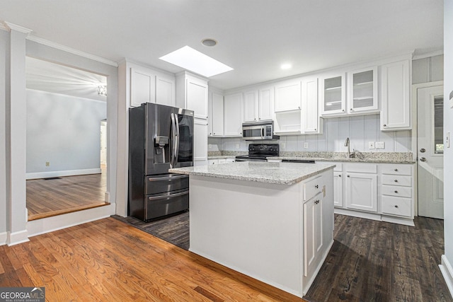 2701 Log Cabin Dr SE, Atlanta, GA 30339 - kitchen with appliances with stainless steel finishes, a skylight, white cabinets, ornamental molding, and recessed lighting