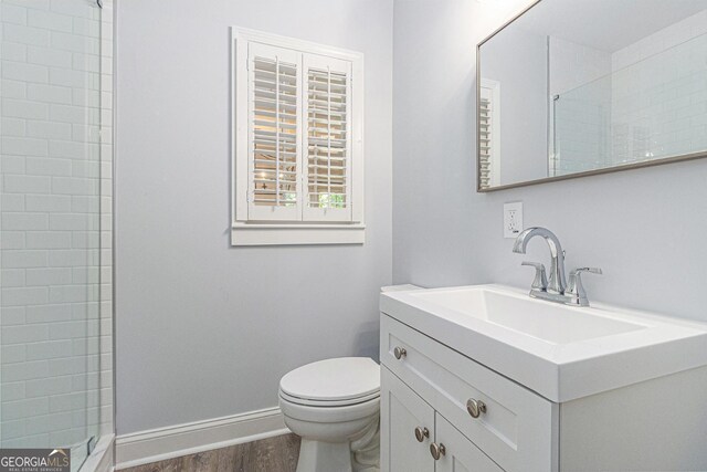2701 Log Cabin Dr SE, Atlanta, GA 30339 - bathroom with toilet, vanity, wood finished floors, baseboards, and a tile shower