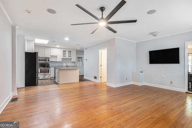 2701 Log Cabin Dr SE, Atlanta, GA 30339 - unfurnished living room featuring crown molding, light wood finished floors, baseboards, a ceiling fan, and recessed lighting