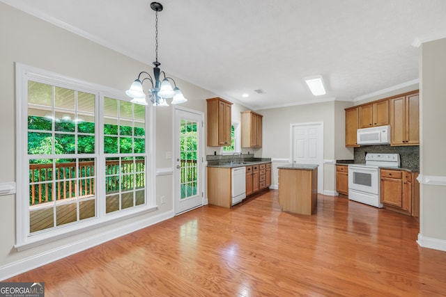 1315 Crane Ct, Mcdonough, GA 30252 - kitchen with white appliances, a chandelier, light wood-style floors, a kitchen island, and ornamental molding