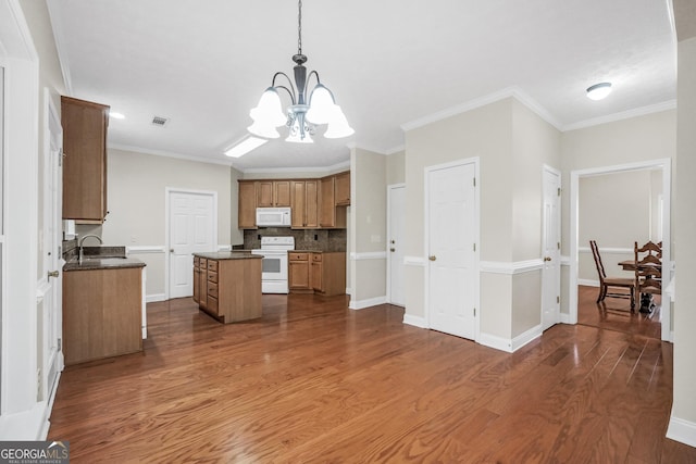 1315 Crane Ct, Mcdonough, GA 30252 - kitchen with white appliances, a chandelier, a center island, dark wood-type flooring, and a sink