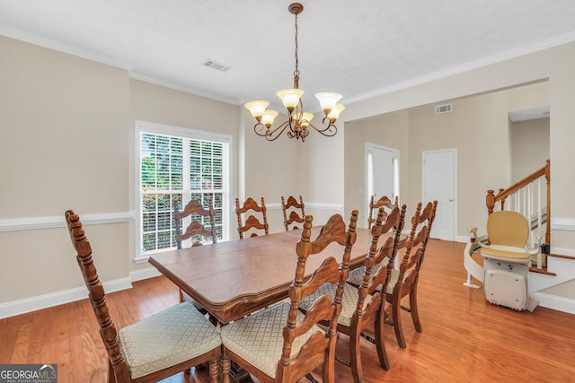 1315 Crane Ct, Mcdonough, GA 30252 - dining room with a chandelier, light wood-type flooring, ornamental molding, baseboards, and stairway