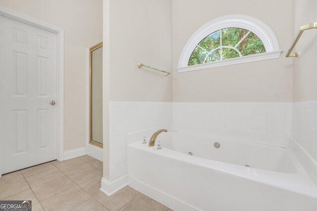 1315 Crane Ct, Mcdonough, GA 30252 - bathroom featuring a tub with jets, tile patterned flooring, a shower with door, and baseboards
