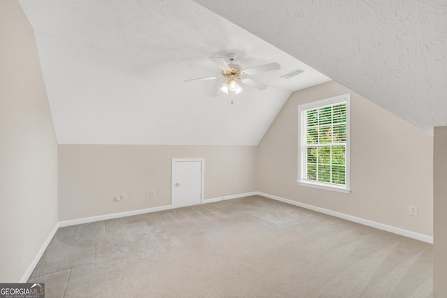 1315 Crane Ct, Mcdonough, GA 30252 - additional living space with baseboards, carpet, a ceiling fan, vaulted ceiling, and a textured ceiling