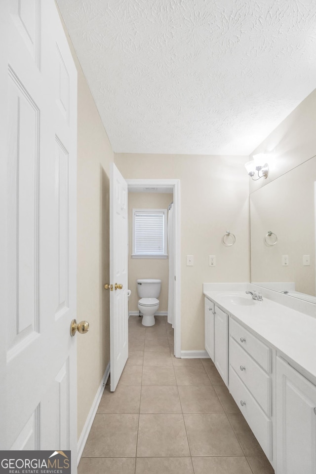 1315 Crane Ct, Mcdonough, GA 30252 - bathroom with vanity, toilet, a textured ceiling, tile patterned flooring, and baseboards
