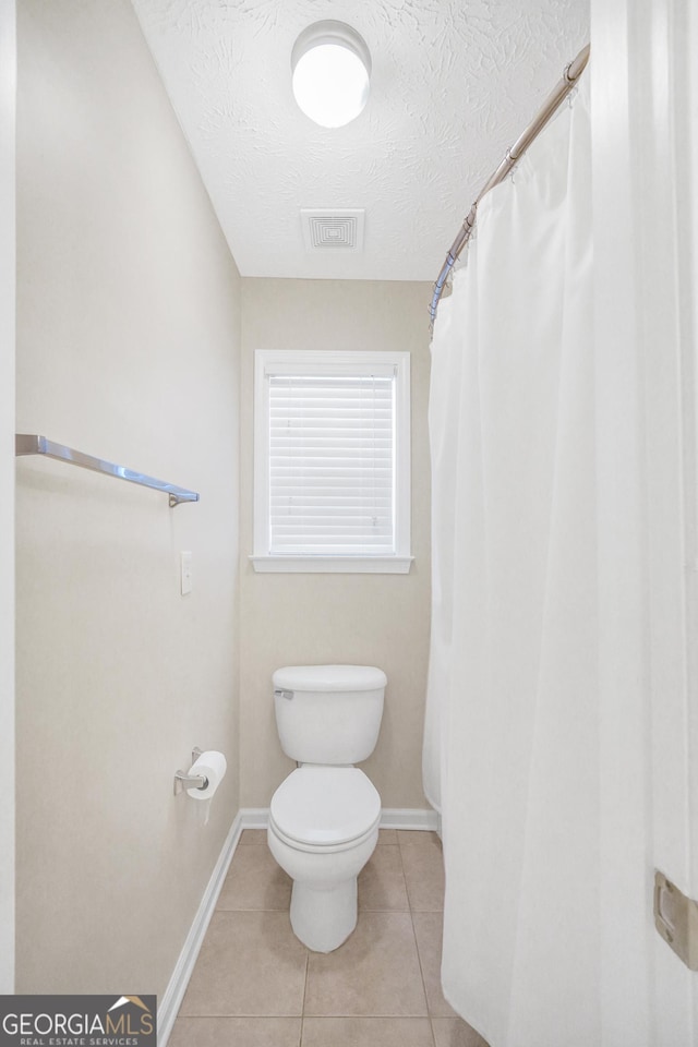 1315 Crane Ct, Mcdonough, GA 30252 - full bathroom with toilet, a textured ceiling, baseboards, tile patterned floors, and curtained shower