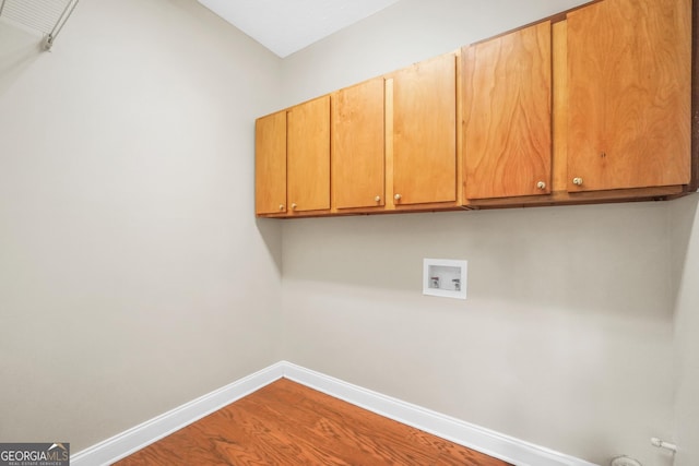 1315 Crane Ct, Mcdonough, GA 30252 - laundry area with cabinet space, washer hookup, baseboards, and wood finished floors