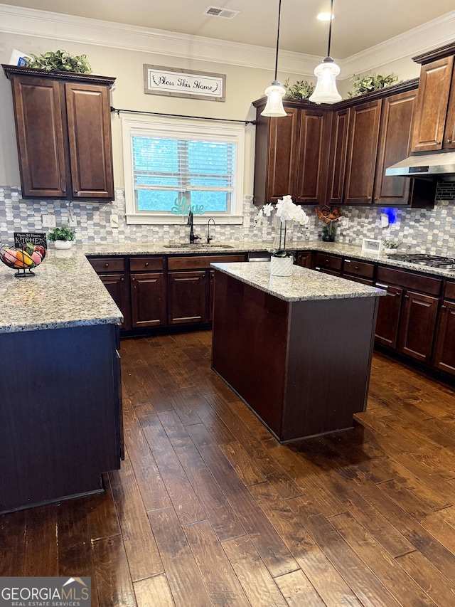 1869 Schofield Dr, Hampton, GA 30228 - kitchen featuring a center island, dark wood-style flooring, light stone counters, tasteful backsplash, and stainless steel gas cooktop