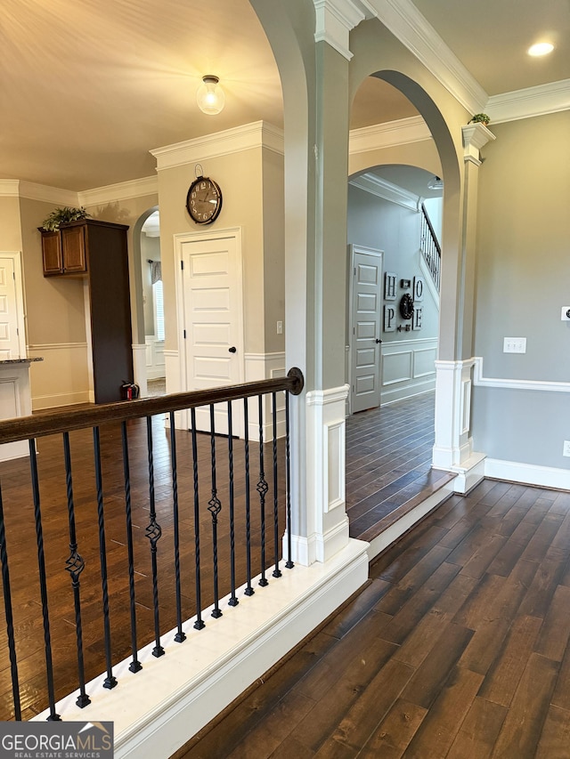 1869 Schofield Dr, Hampton, GA 30228 - corridor featuring dark wood finished floors, crown molding, a decorative wall, wainscoting, and arched walkways