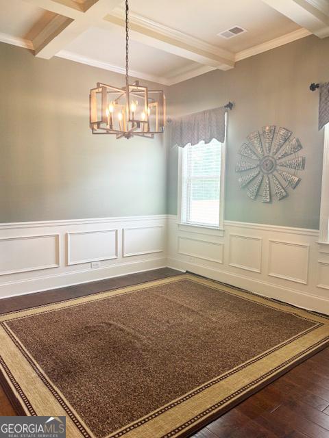 1869 Schofield Dr, Hampton, GA 30228 - unfurnished dining area featuring beamed ceiling, a chandelier, crown molding, dark wood-style floors, and a wainscoted wall