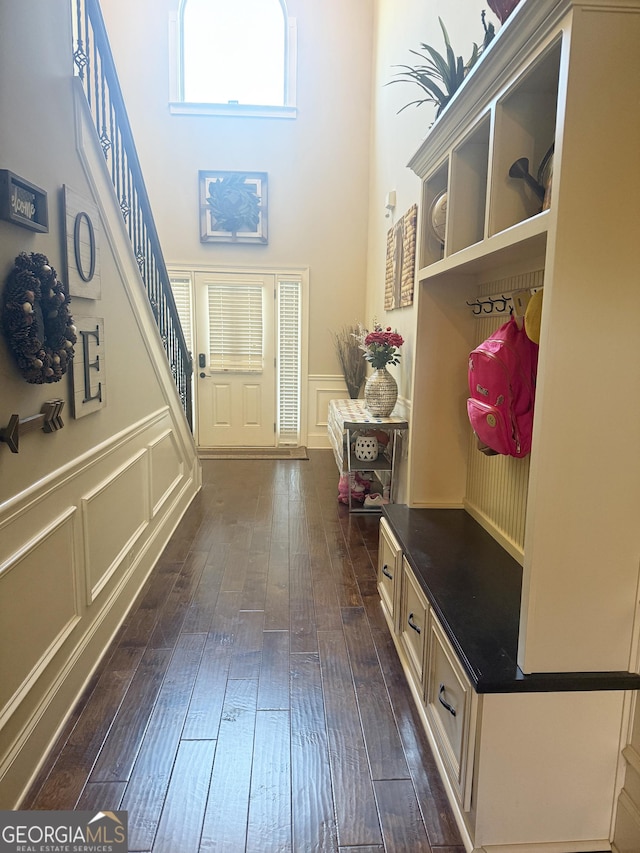 1869 Schofield Dr, Hampton, GA 30228 - mudroom with dark wood-type flooring, a decorative wall, a towering ceiling, and a wainscoted wall