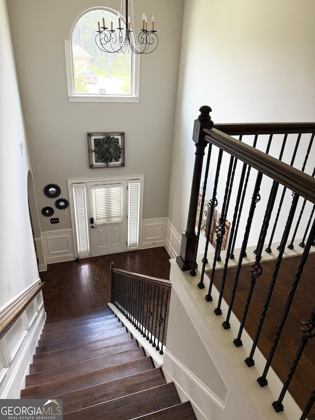 1869 Schofield Dr, Hampton, GA 30228 - stairway featuring a decorative wall, wood finished floors, a wainscoted wall, and a high ceiling