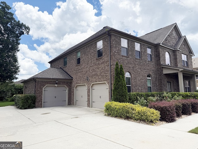 1869 Schofield Dr, Hampton, GA 30228 - view of side of property featuring brick siding, concrete driveway, and an attached garage