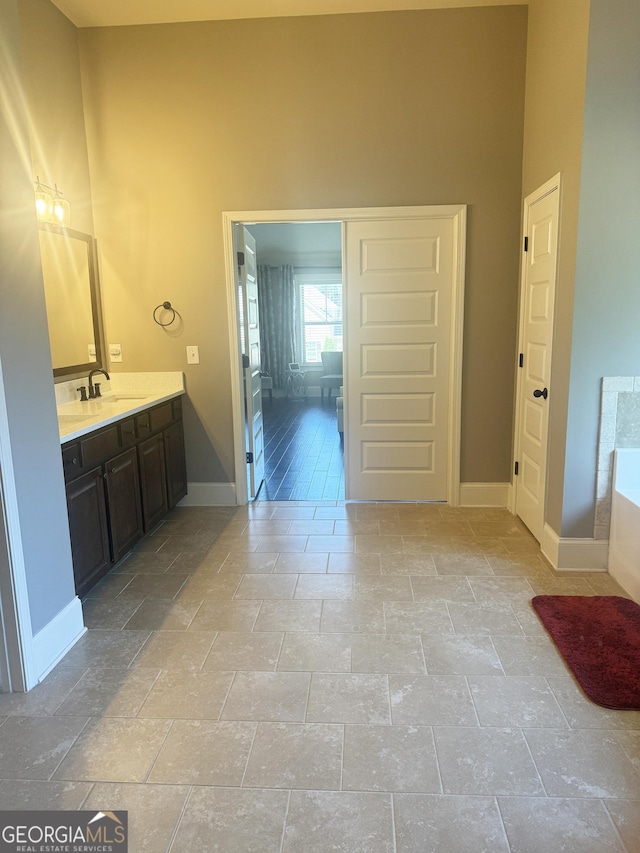 1869 Schofield Dr, Hampton, GA 30228 - bathroom with vanity, baseboards, a bathtub, and stone tile floors