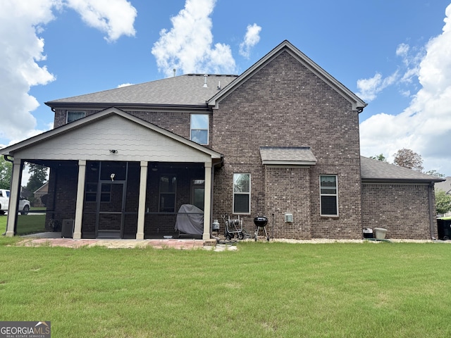1869 Schofield Dr, Hampton, GA 30228 - back of house featuring a sunroom, brick siding, a lawn, and roof with shingles
