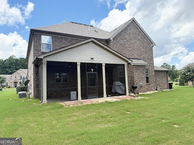 1869 Schofield Dr, Hampton, GA 30228 - rear view of house featuring a sunroom, brick siding, a yard, and roof with shingles