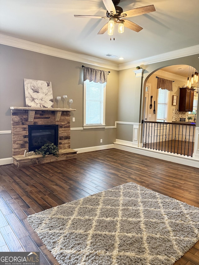 1869 Schofield Dr, Hampton, GA 30228 - unfurnished living room featuring crown molding, arched walkways, ceiling fan, hardwood / wood-style flooring, and a fireplace