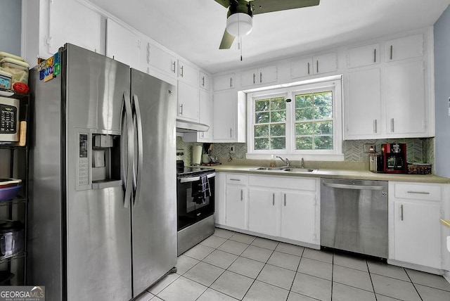 4110 Belvedere Dr, Gainesville, GA 30506 - kitchen featuring appliances with stainless steel finishes, under cabinet range hood, a sink, light tile patterned floors, and light countertops