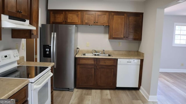 114 Sycamore Rd SW, Milledgeville, GA 31061 - kitchen featuring white appliances, a sink, under cabinet range hood, light wood-style floors, and light countertops