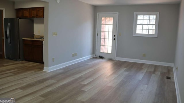 114 Sycamore Rd SW, Milledgeville, GA 31061 - unfurnished dining area with light wood-type flooring, a sink, and baseboards