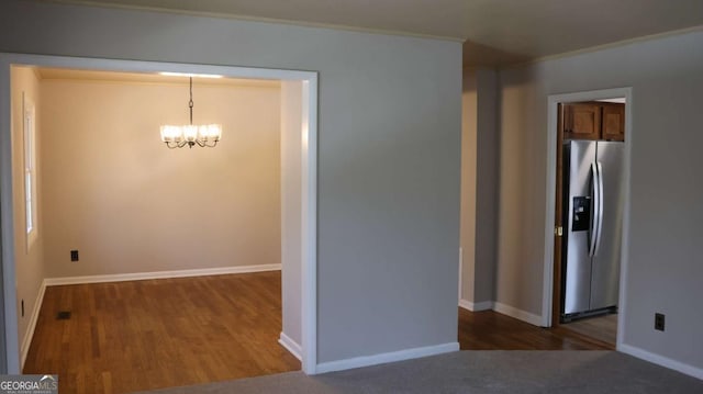 114 Sycamore Rd SW, Milledgeville, GA 31061 - unfurnished dining area with a chandelier, wood finished floors, crown molding, and baseboards