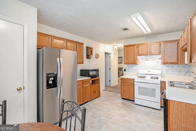 7847 Dogwood Way, Douglasville, GA 30134 - kitchen featuring stainless steel refrigerator with ice dispenser, white range with gas cooktop, a sink, black microwave, and under cabinet range hood