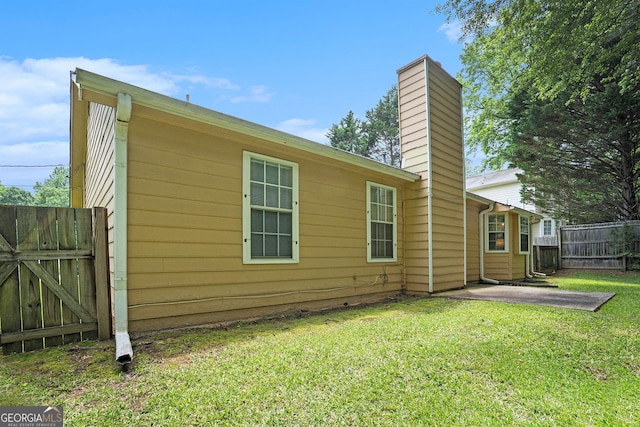 7847 Dogwood Way, Douglasville, GA 30134 - view of home's exterior featuring a chimney, a patio, and a gate
