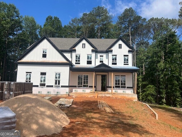 3425 Dr Bramblett Rd, Cumming, GA 30028 - view of front of house with board and batten siding, a porch, and view of scattered trees
