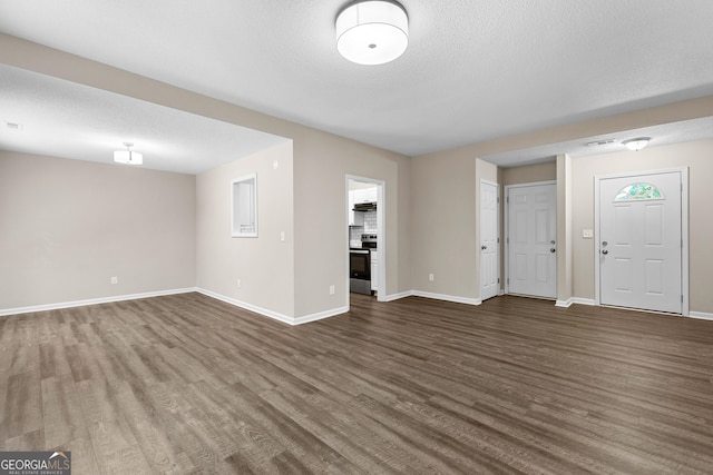 80 Corn Row Ct, Newnan, GA 30263 - unfurnished living room featuring dark wood-type flooring, baseboards, and a textured ceiling