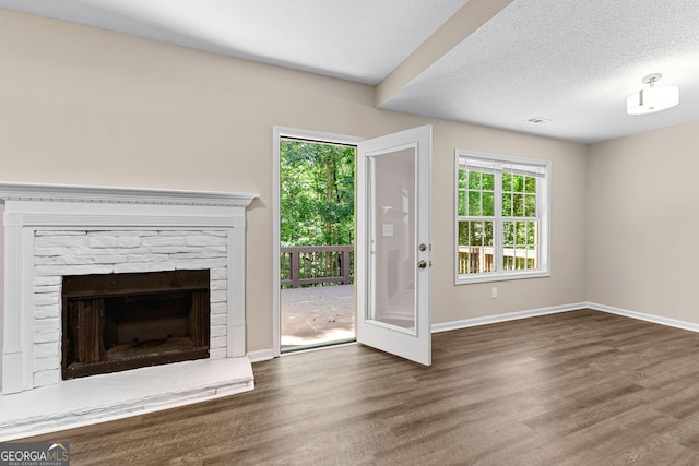 80 Corn Row Ct, Newnan, GA 30263 - unfurnished living room featuring baseboards, wood finished floors, a fireplace, and a textured ceiling
