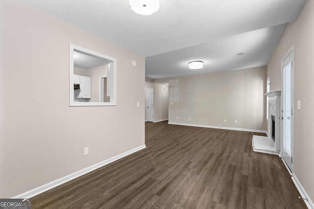 80 Corn Row Ct, Newnan, GA 30263 - unfurnished room featuring dark wood-style floors, a fireplace with raised hearth, and baseboards